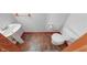 Compact bathroom with white toilet, pedestal sink, and brown tile flooring at 1199 Oak Leaf Rd, Franklin, IN 46131