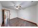 Bright bedroom with dark wood floors, ceiling fan, and entry to the hallway at 1199 Oak Leaf Rd, Franklin, IN 46131