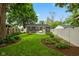 Secluded backyard with well-manicured lawn, mature trees, fire pit, and white vinyl fence at 1240 Hamilton Dr, Noblesville, IN 46060