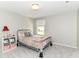 Bright bedroom with gray walls, a cozy bed, and a window overlooking the yard at 12994 Dekoven Dr, Fishers, IN 46037