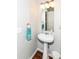 A powder room featuring a pedestal sink, sleek fixtures, and a modern mirror, providing a functional and stylish space at 12994 Dekoven Dr, Fishers, IN 46037
