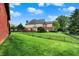 Lush backyard with large lawn area, mature trees, and an attractive house featuring brick and siding at 14492 Allison Dr, Carmel, IN 46033