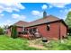 Large backyard with a deck, lush lawn, mature trees, and fire pit area at 14492 Allison Dr, Carmel, IN 46033