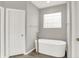 This bright bathroom features a freestanding tub with modern fixtures and a unique glass block window at 14492 Allison Dr, Carmel, IN 46033