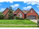 Charming brick home with lush lawn, mature trees and a two-car garage, set under a blue sky at 14492 Allison Dr, Carmel, IN 46033