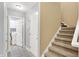 Hallway with staircase, neutral paint, tile flooring, and open access to the laundry room at 14492 Allison Dr, Carmel, IN 46033