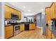 An open kitchen features wooden cabinetry, granite countertops, stainless steel appliances, and hardwood flooring at 14492 Allison Dr, Carmel, IN 46033