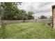 Spacious backyard with a well-maintained lawn, wooden fence, and a quaint fire pit area at 1601 Southern Ave, Beech Grove, IN 46107