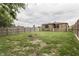 Spacious backyard featuring a stone exterior house, wooden fence, green grass, and a charming fire pit at 1601 Southern Ave, Beech Grove, IN 46107