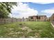 Spacious backyard featuring a stone exterior house, wooden fence, green grass, and a charming fire pit at 1601 Southern Ave, Beech Grove, IN 46107