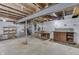 Unfinished basement with work tables, wood storage shelving, concrete floors, and visible ceiling beams and ductwork at 1601 Southern Ave, Beech Grove, IN 46107