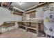 Basement with wood laminate flooring, workbench, utility sink, water heater and storage shelves at 1601 Southern Ave, Beech Grove, IN 46107