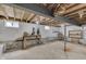 Unfinished basement with concrete floor, windows, support beam, shelving and exposed ceiling joists at 1601 Southern Ave, Beech Grove, IN 46107