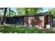 An exterior view of the back of the home with a screened in porch and various clutter in the yard at 1619 Crest Ct, Indianapolis, IN 46214