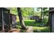 A shady backyard with mature trees, sheds, and a concrete paver pathway at 1619 Crest Ct, Indianapolis, IN 46214