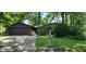 Ranch style home with stone and brown siding, green lawn, and mature trees at 1619 Crest Ct, Indianapolis, IN 46214