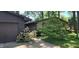Inviting entrance featuring a stone facade, a two-car garage, flower beds, and mature landscaping at 1619 Crest Ct, Indianapolis, IN 46214