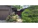 Inviting entrance featuring a stone facade, a two-car garage, flower beds, and mature landscaping at 1619 Crest Ct, Indianapolis, IN 46214