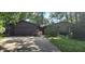 Charming home featuring a stone facade and a two-car garage surrounded by mature trees and lush landscaping at 1619 Crest Ct, Indianapolis, IN 46214