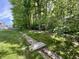A long trench crosses through the grassy backyard lined with tall, mature trees and lush greenery at 167 Hilltop Farms Blvd, New Whiteland, IN 46184