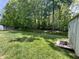Expansive backyard with green grass, a storage shed, and plenty of shade from the surrounding trees at 167 Hilltop Farms Blvd, New Whiteland, IN 46184