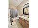 Bathroom with a shower-tub combo, toilet, and a vanity with a sink and black framed mirror at 167 Hilltop Farms Blvd, New Whiteland, IN 46184