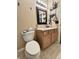 Neutral-toned bathroom featuring a toilet and a vanity with a sink and black framed mirror at 167 Hilltop Farms Blvd, New Whiteland, IN 46184