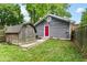 Spacious backyard with a shed, back entrance to home, grass and wooden fence at 1841 New St, Indianapolis, IN 46203