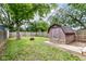 Fenced backyard featuring a shed and mature trees for shade at 1841 New St, Indianapolis, IN 46203