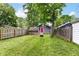 Large fenced backyard with grass, a shed, and a fire pit at 1841 New St, Indianapolis, IN 46203