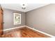 A cozy bedroom featuring hardwood floors, neutral walls and natural light from a window at 1841 New St, Indianapolis, IN 46203
