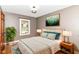Stylishly furnished bedroom with hardwood floors, a large bed, lamps, and a calming painting at 1841 New St, Indianapolis, IN 46203