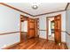 Bedroom features hardwood floors, light grey walls, wood trim, and access to a bathroom and living room at 1841 New St, Indianapolis, IN 46203