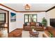 Cozy living room with leather sofa, area rug, and view to adjacent room at 1841 New St, Indianapolis, IN 46203