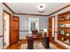 Office features hardwood floors, wood trim, light grey walls, built-in shelves, and a window at 1841 New St, Indianapolis, IN 46203