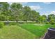 Lush green backyard with mature trees, black fence, and potential for landscaping at 1936 Southernwood Ln, Indianapolis, IN 46231