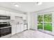 Bright kitchen featuring white cabinets, stainless steel appliances, and sliding glass doors to the backyard at 1936 Southernwood Ln, Indianapolis, IN 46231