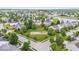 Scenic aerial view of a community with mature trees, a playground, green spaces, and a tranquil pond at 19534 Forsythe Dr, Noblesville, IN 46060