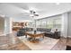Bright living area showcasing an open floor plan and hardwood floors, with a large grey sofa at 19534 Forsythe Dr, Noblesville, IN 46060