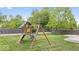 Wooden play set with swings, slide, and climbing features in a grassy backyard at 19534 Forsythe Dr, Noblesville, IN 46060