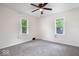 Bright bedroom with a ceiling fan, two windows, and carpeted floors at 2105 Mayfair Dr, Indianapolis, IN 46260