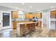 Well-lit kitchen featuring a kitchen island with bar stool seating, wooden cabinets, and stainless steel appliances at 241 Liberty Blvd, Mooresville, IN 46158