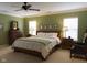 Bright bedroom with olive green walls and classic wooden furniture and a ceiling fan at 2445 N Delaware St, Indianapolis, IN 46205