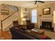 Inviting living room features a fireplace, two leather armchairs, and staircase at 2445 N Delaware St, Indianapolis, IN 46205