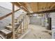 Unfinished basement with concrete walls, exposed beams, and a staircase at 301 Leeds Ave, Indianapolis, IN 46201