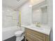 Bright bathroom with marble-style tiling, wooden vanity, and a shower/tub combo at 301 Leeds Ave, Indianapolis, IN 46201