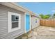 Back exterior featuring gray siding, a turquoise door, and a wood fence at 301 Leeds Ave, Indianapolis, IN 46201