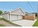 Spacious three-car garage with white doors and a large driveway, complementing the home's gray siding at 301 Leeds Ave, Indianapolis, IN 46201