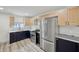 This kitchen features stainless steel appliances, modern two-tone cabinetry, and stylish backsplash at 301 Leeds Ave, Indianapolis, IN 46201