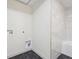 Laundry room with black tile floors, marble style tile shower and clean, bright aesthetic at 301 Leeds Ave, Indianapolis, IN 46201